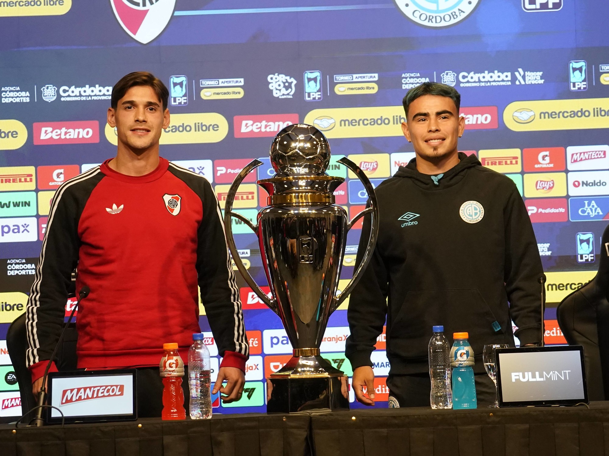 River Plate captain Lucas Martínez Quarta and Belgrano captain Lucas Zelarayán pose with the Apertura trophy during a pre-final press conference in Córdoba.