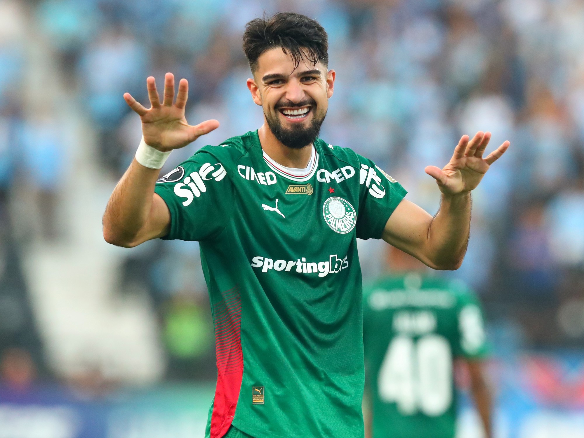 José López, striking for Palmeiras, is celebrated by teammates after a goal or assist in a Copa Libertadores match.