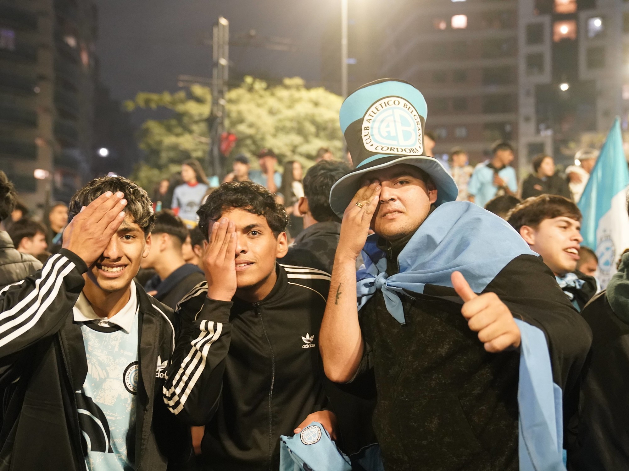 Thousands of jubilant Belgrano football fans celebrating in the streets of Córdoba with flags and fireworks after winning the championship.