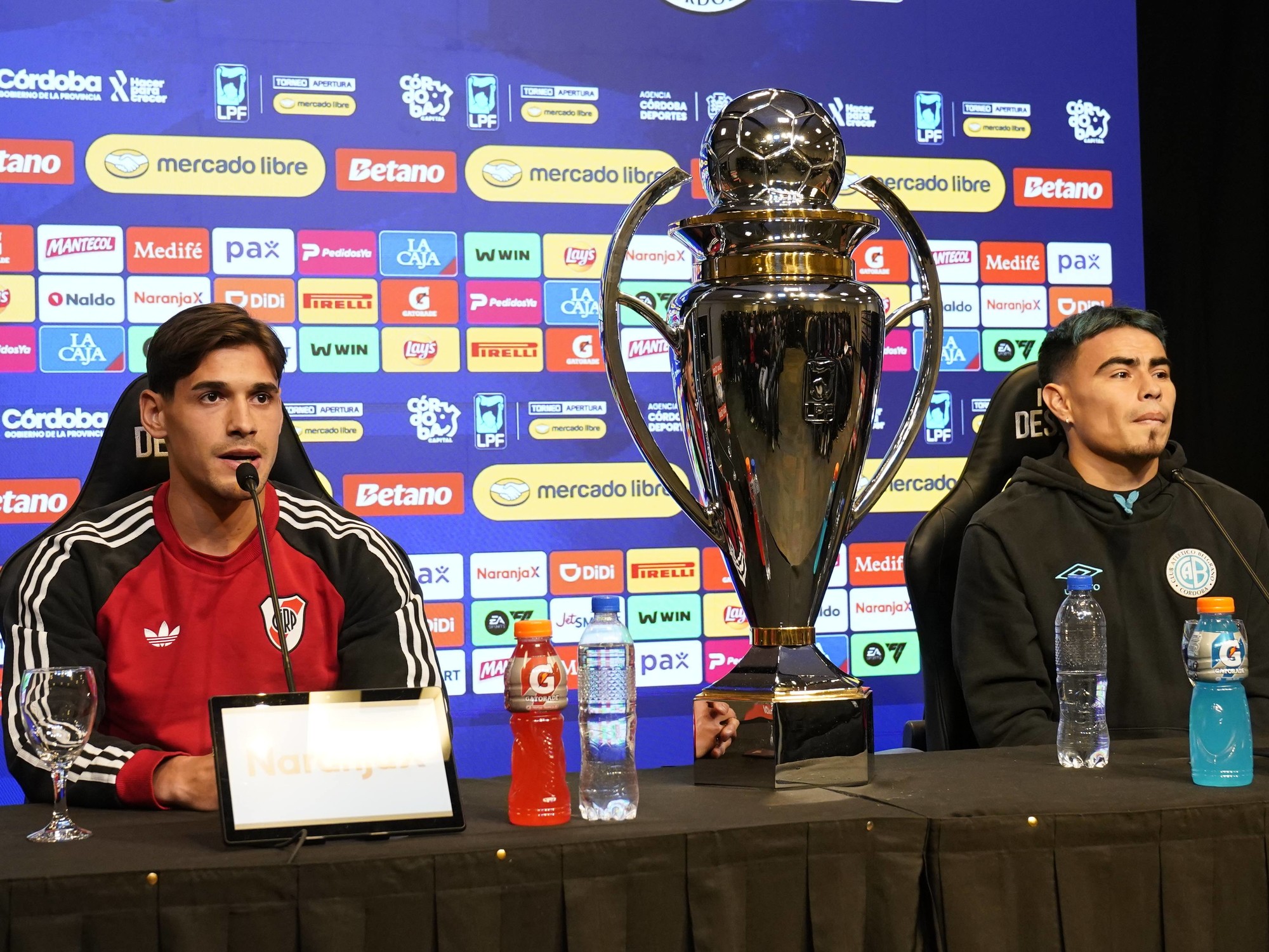River Plate players celebrating a victory with a trophy on the field.