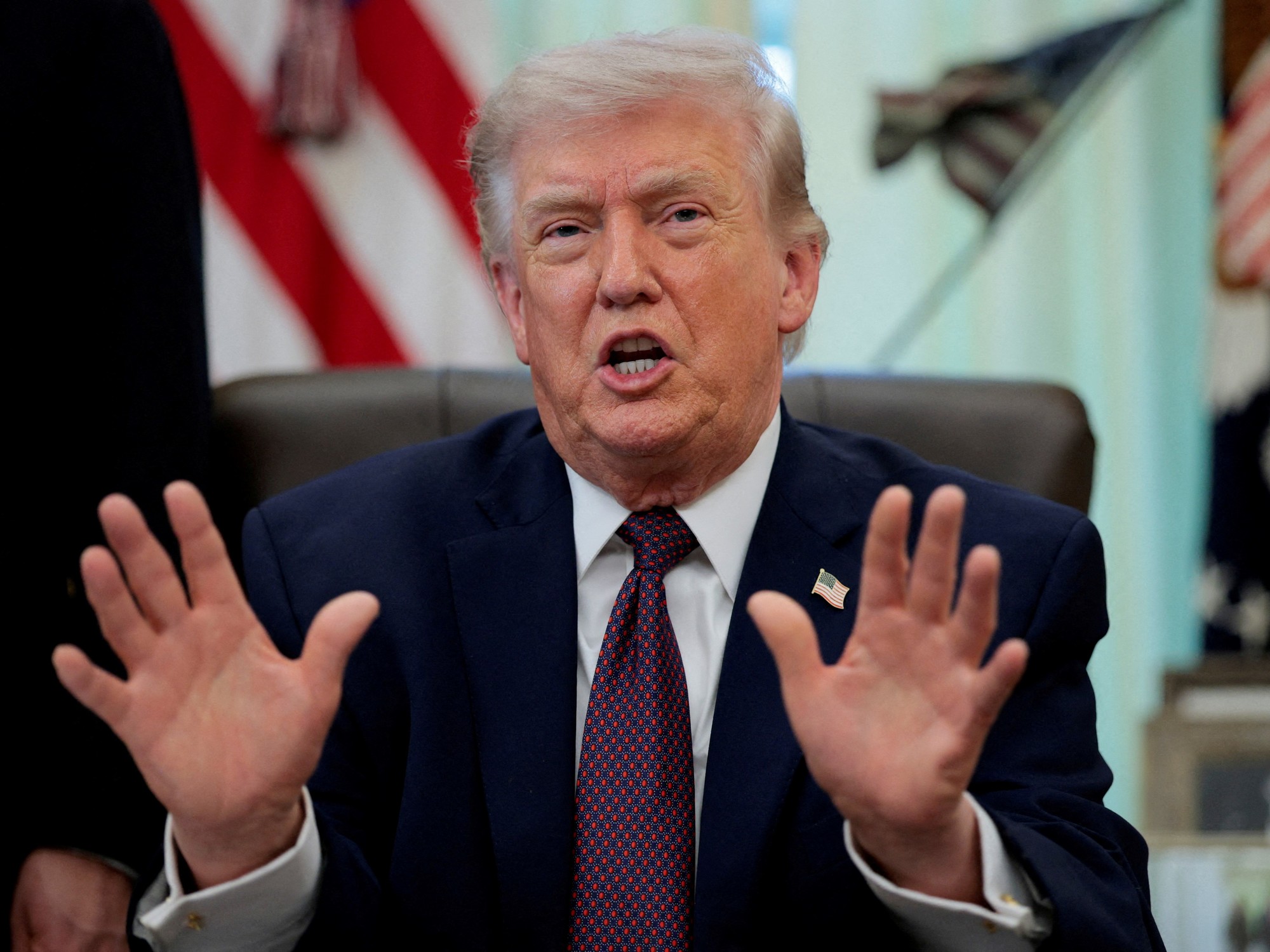 Former US President Donald Trump delivering a statement, with the Cuban flag in the background, symbolizing the ongoing diplomatic tensions.