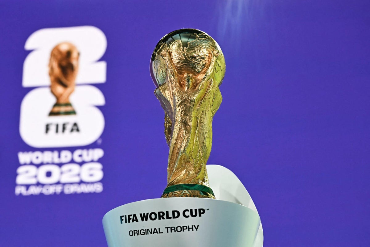 A football pitch with a golden World Cup trophy positioned centrally.