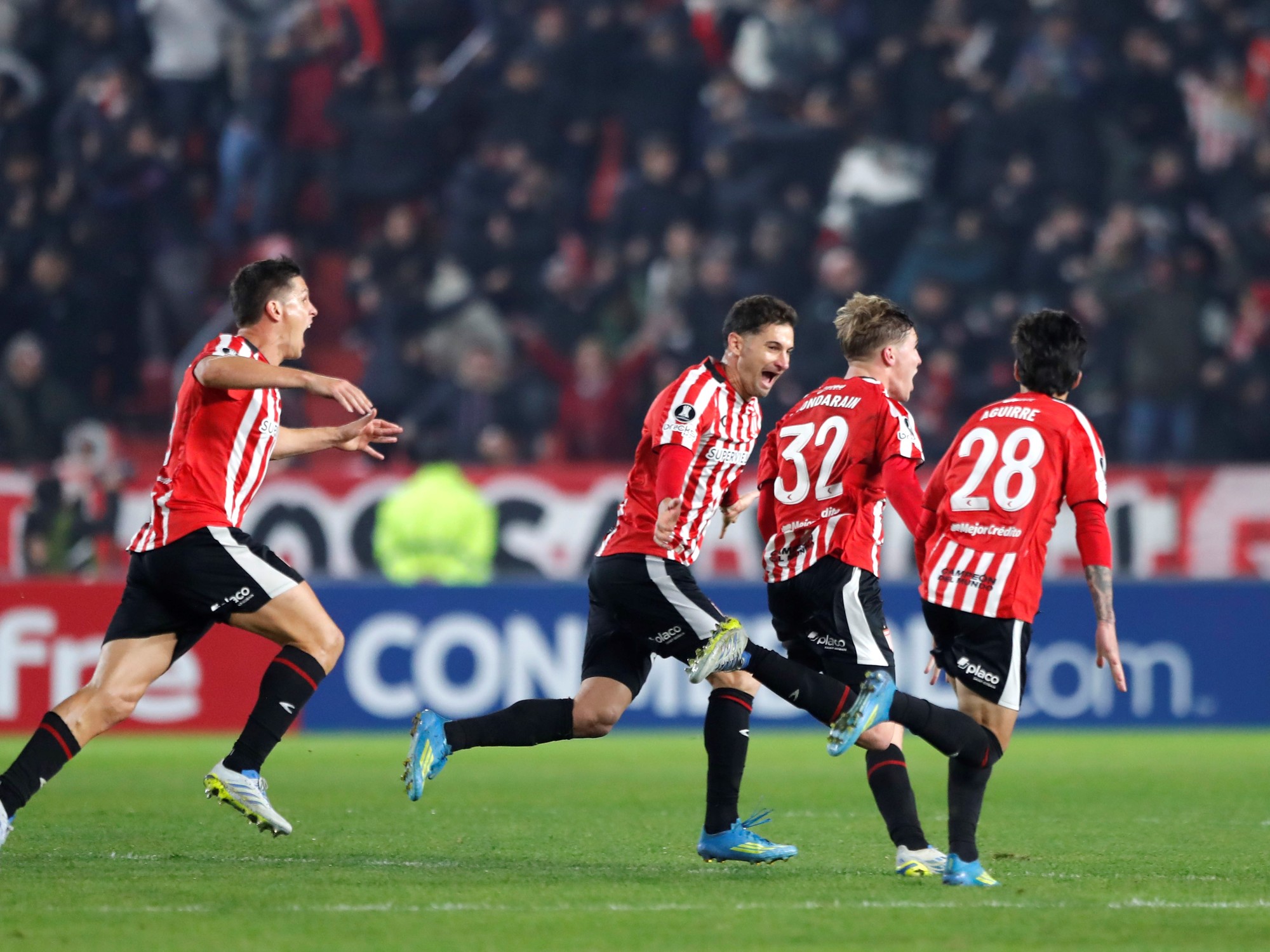 Estudiantes player celebrating a crucial late goal confirmed by VAR.