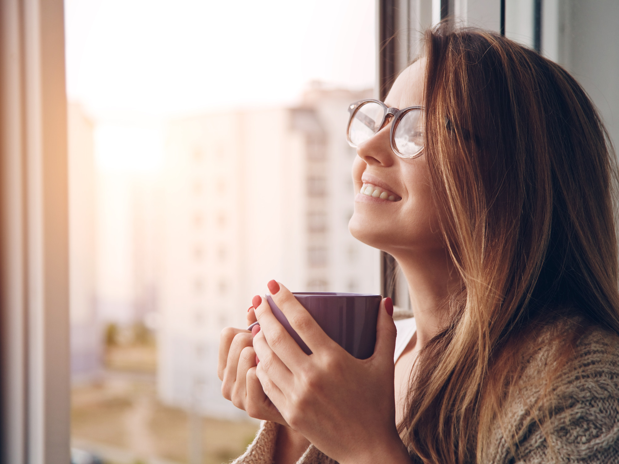 Una persona eligiendo una taza favorita de una estantería.