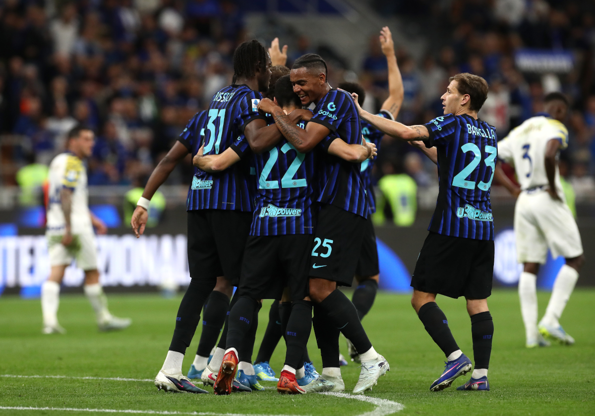 Inter Milan players celebrating on the pitch at San Siro after winning the Serie A title.
