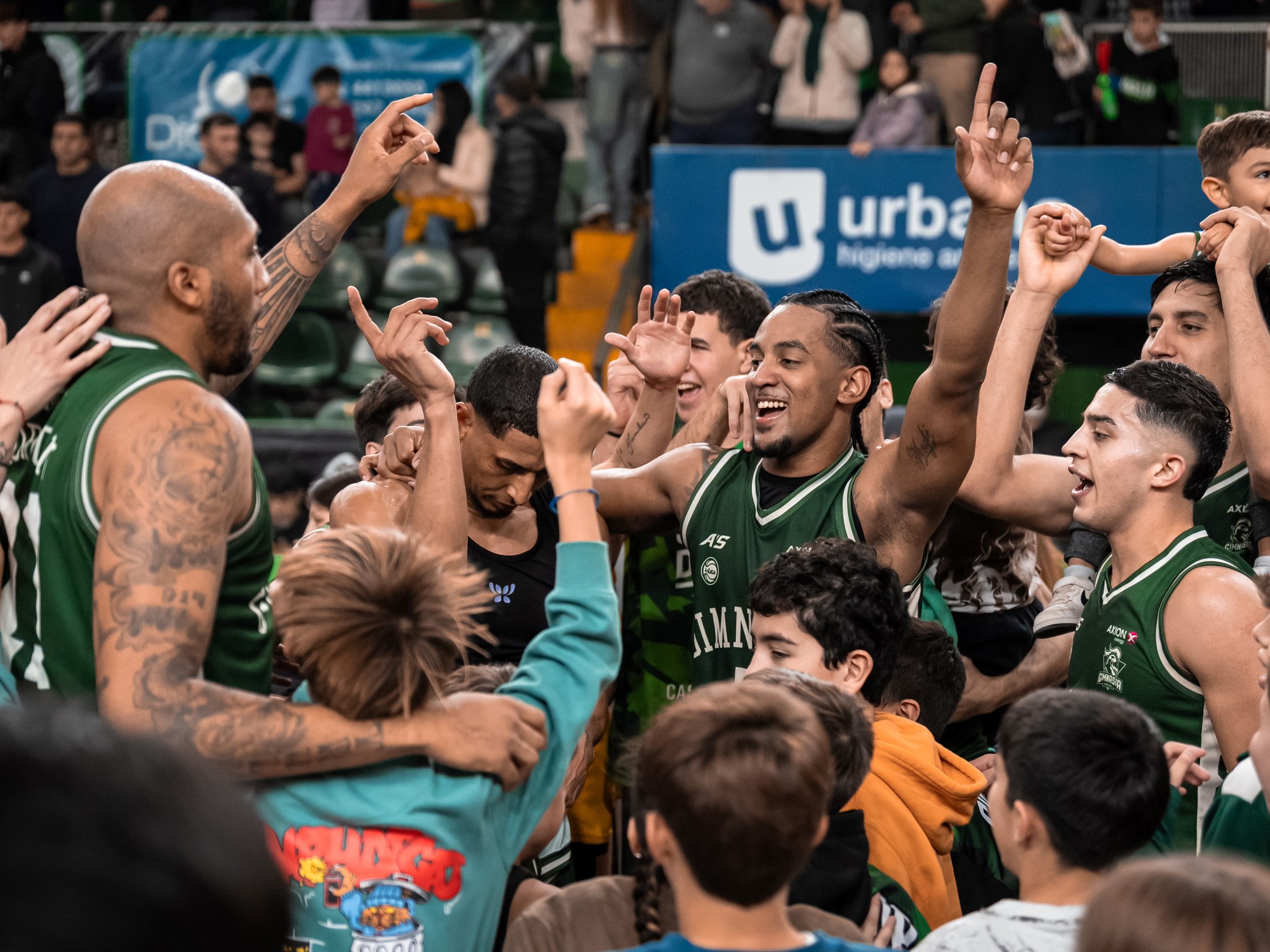 Gimnasia player driving to the basket during a competitive basketball game against Ferro.