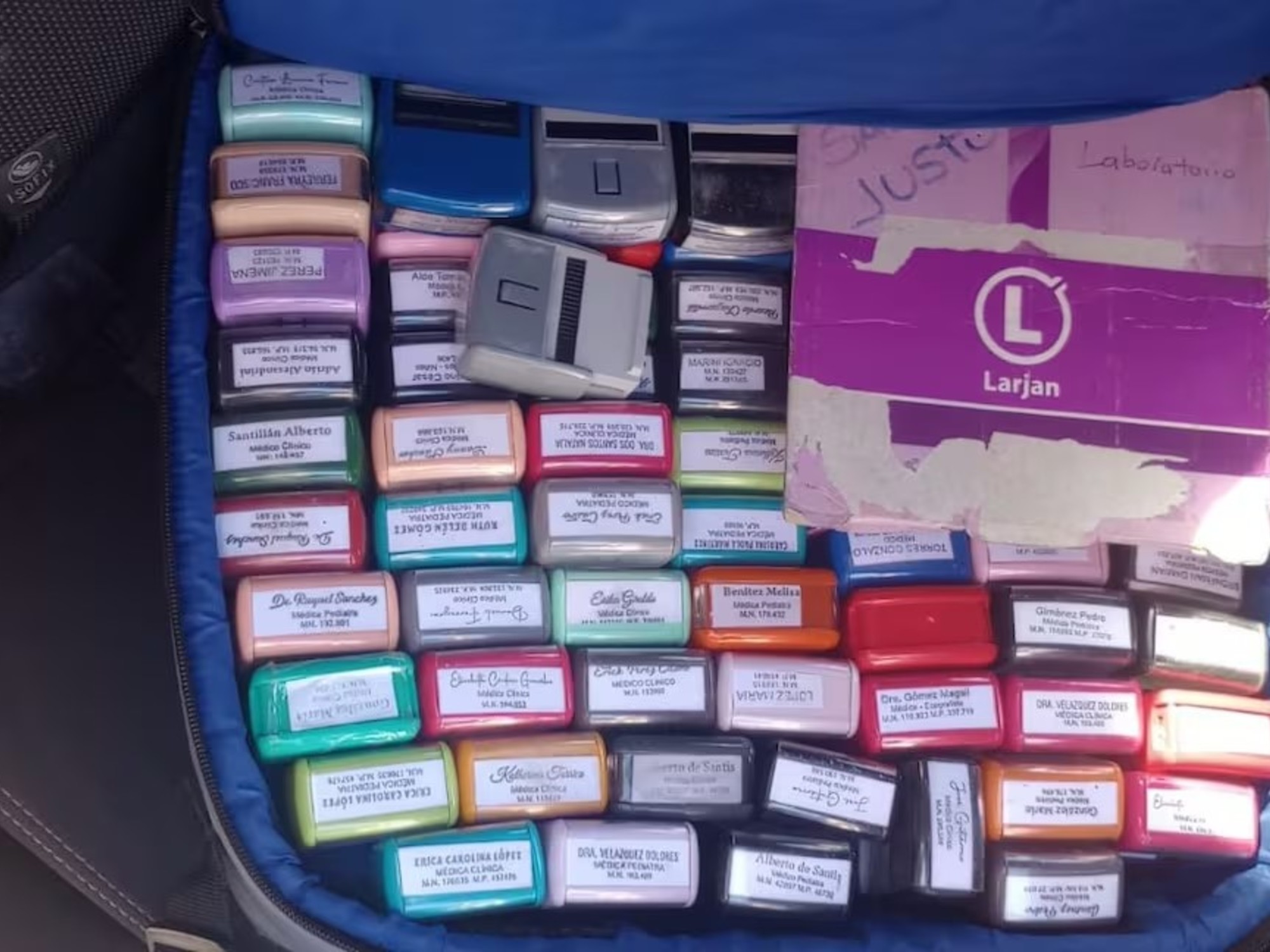 An open suitcase filled with various medical stamps, discovered in a car trunk.
