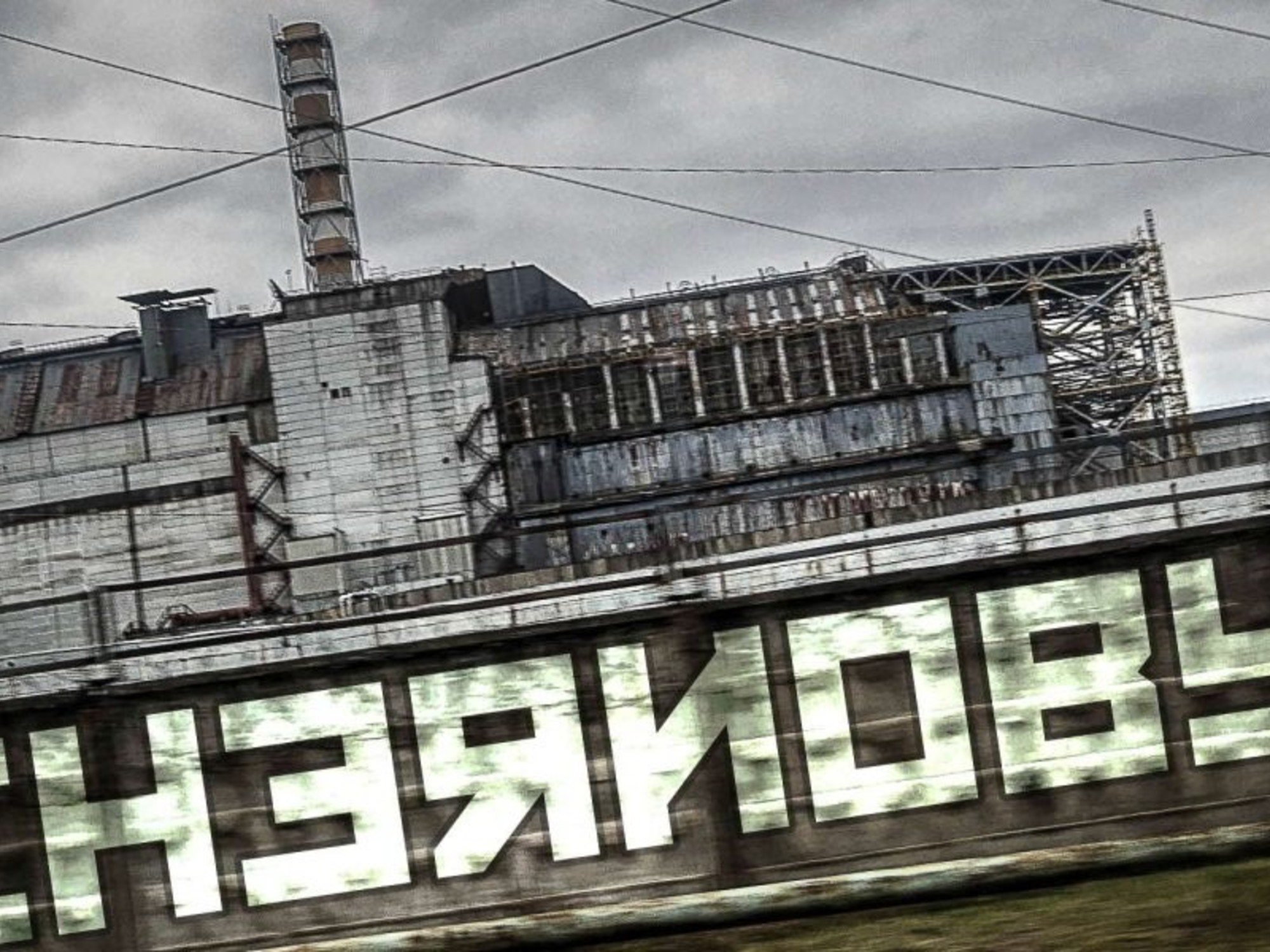 Overgrown vegetation covers abandoned buildings in the Chernobyl Exclusion Zone, illustrating the changing landscape.