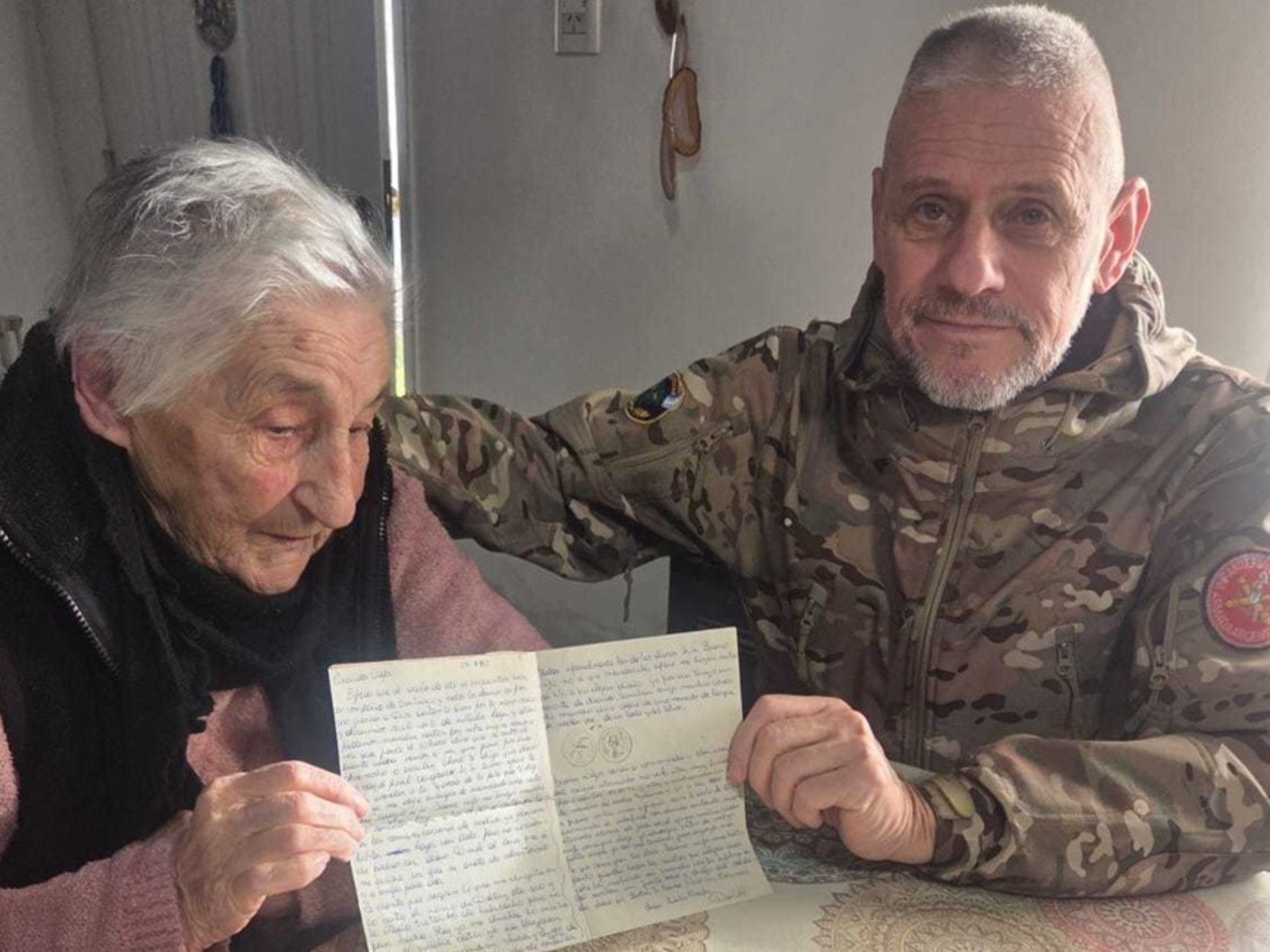Malvinas veteran Héctor Daniel Ponce and his mother embrace as she holds a letter.