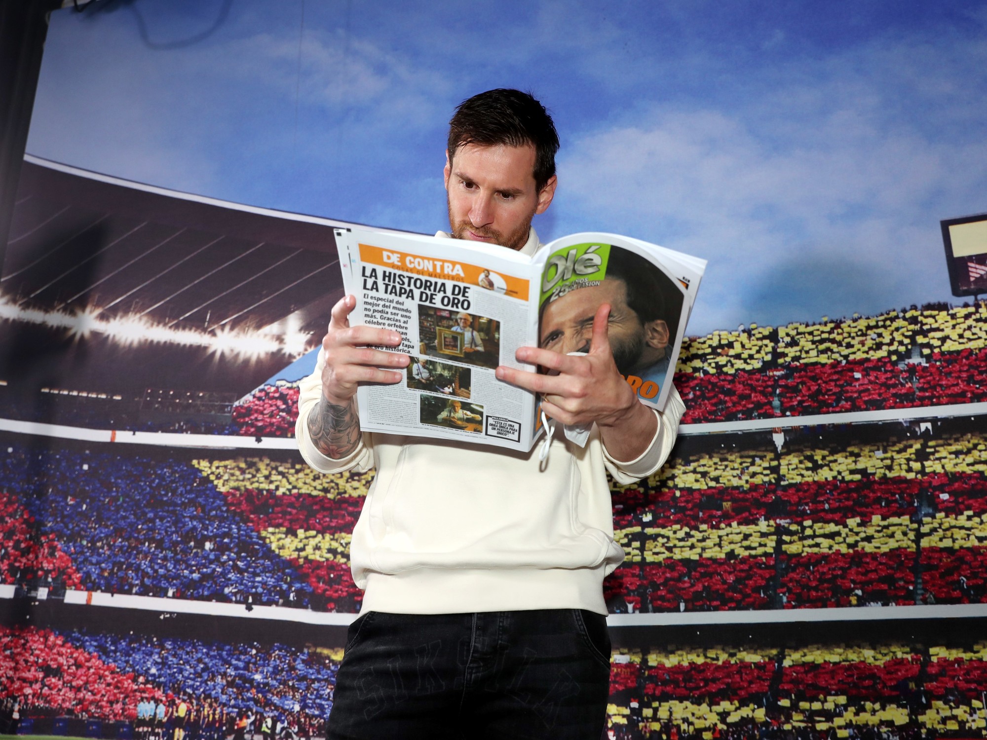 Lionel Messi holding an edition of the Olé newspaper