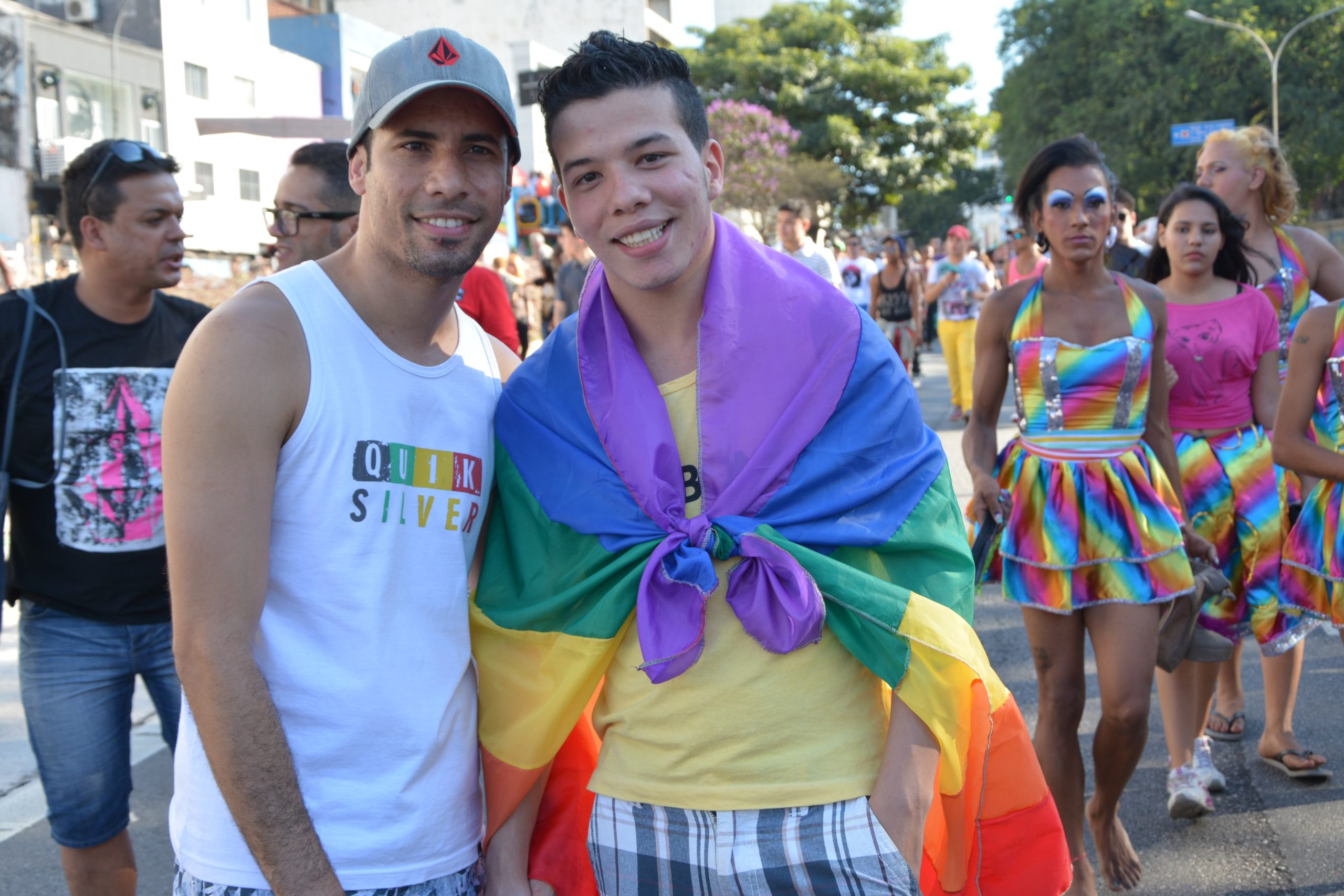 A rainbow flag, a symbol of LGBTQ+ pride, is held aloft at a public event.