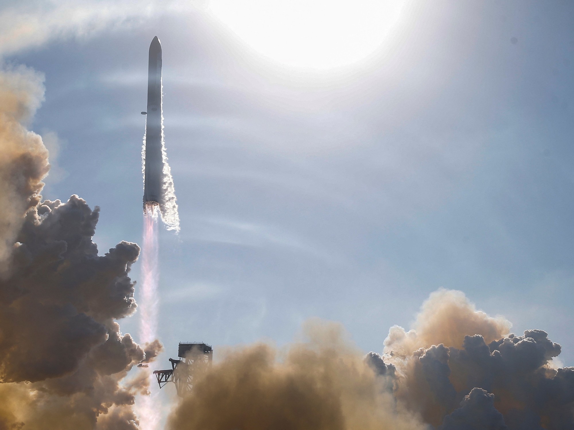 A large SpaceX Starship rocket ignites its engines and ascends from its launchpad in Texas.