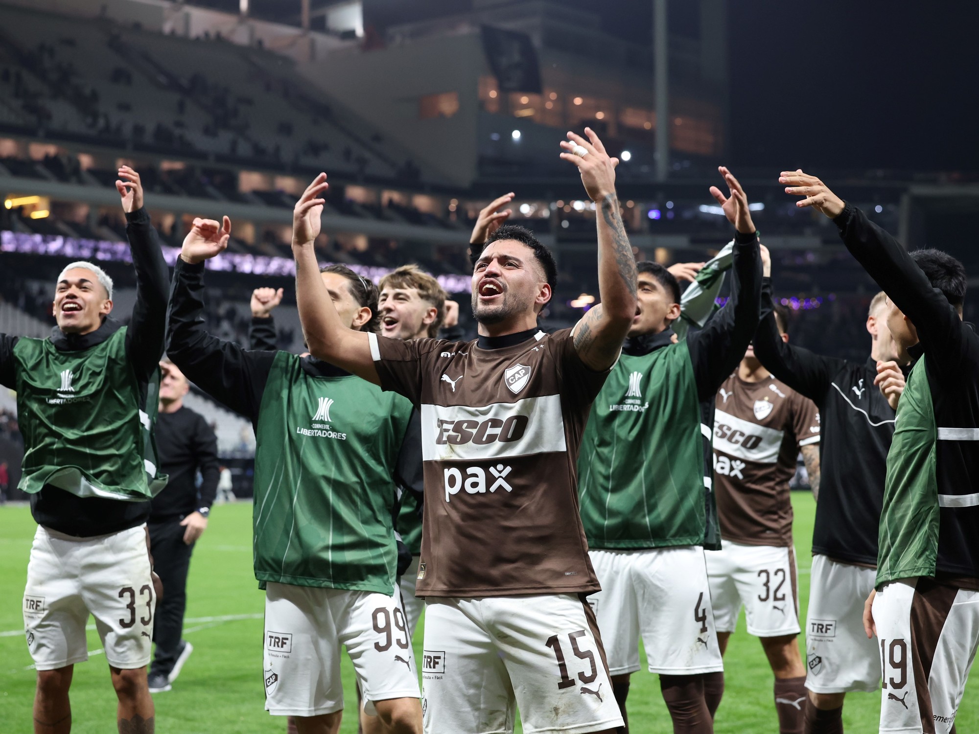 Platense football players celebrating a victory on the pitch.