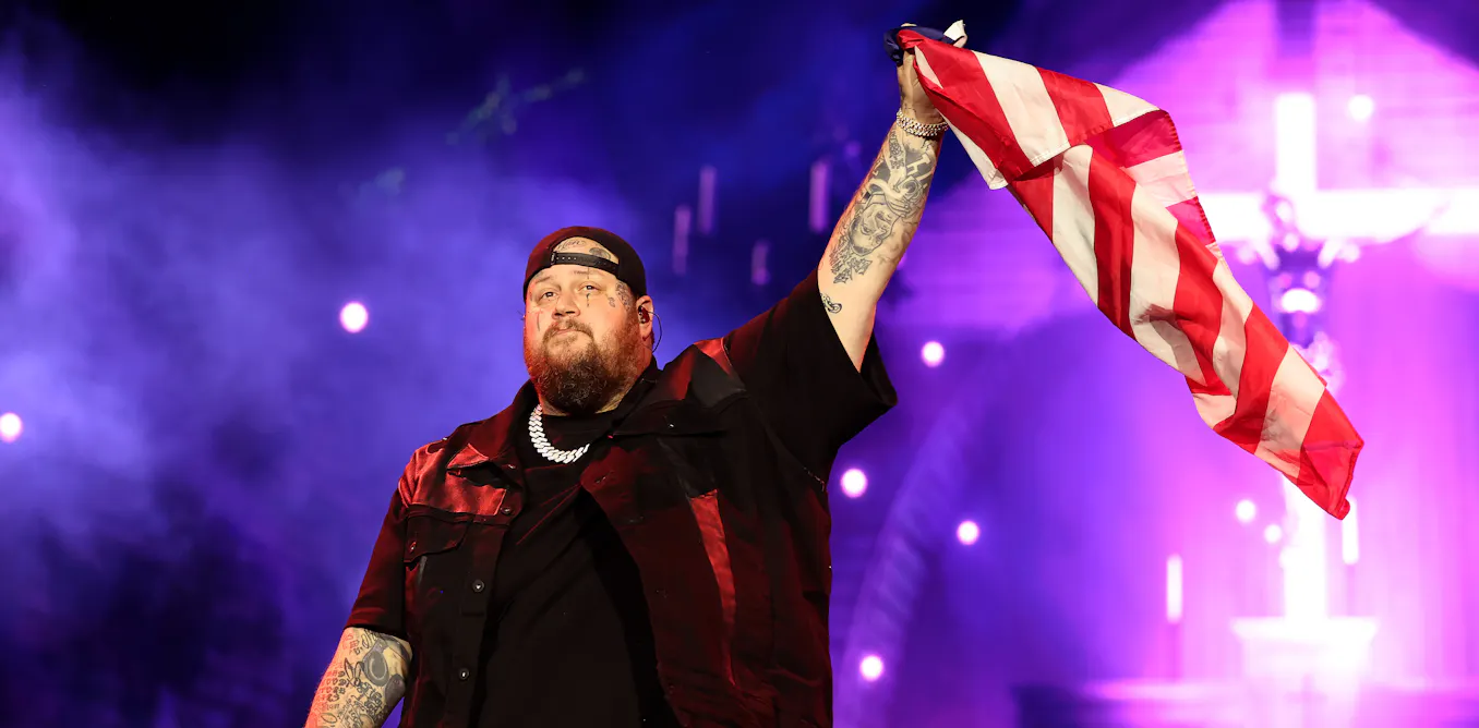 Jelly Roll and Carín León performing, with a subtle nod to the FIFA World Cup 2026 branding in the background.