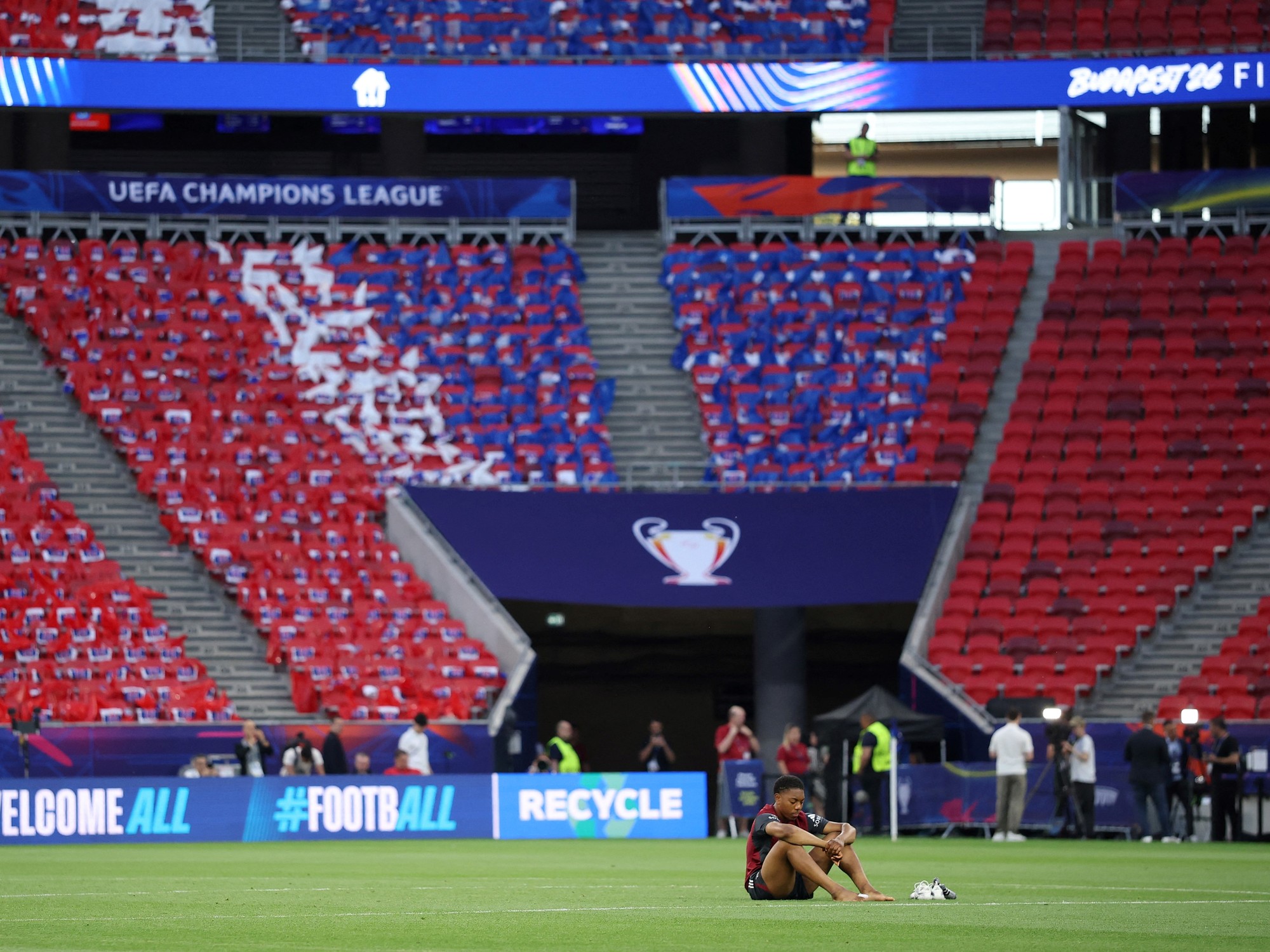 The UEFA Champions League trophy on a green football pitch.