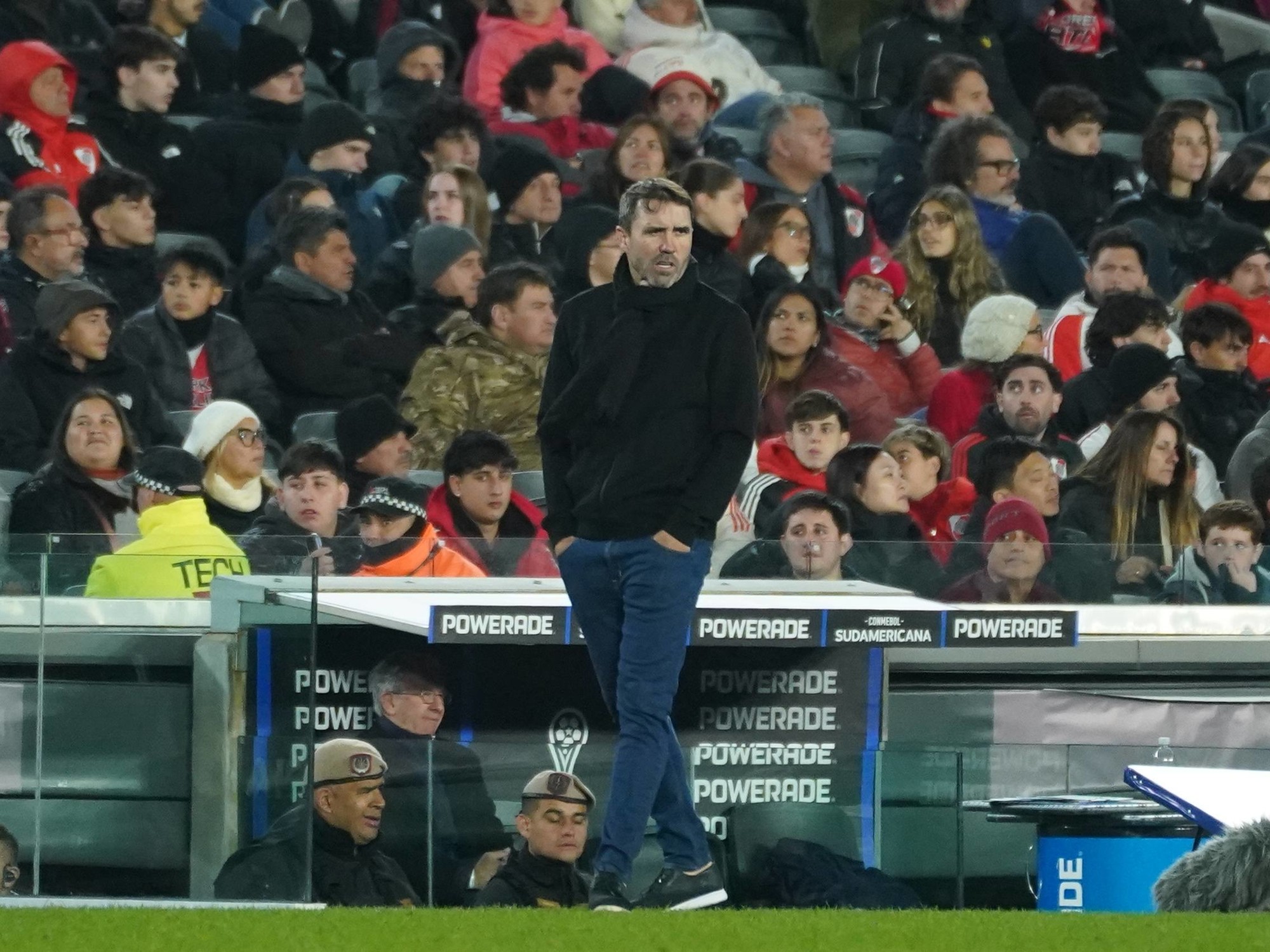 Eduardo Coudet intently observing play from the technical area during a River Plate match