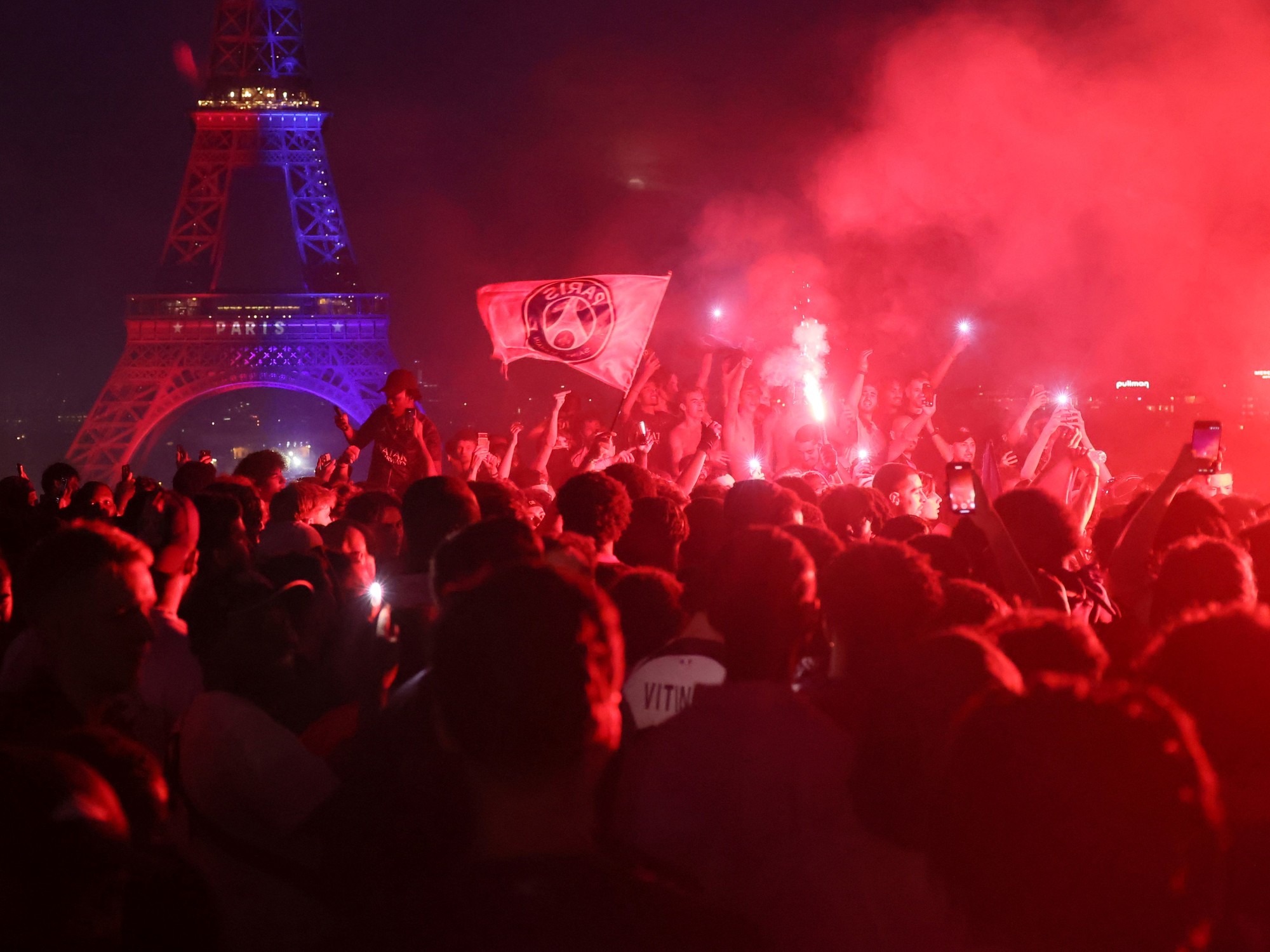 PSG supporters celebrating a Champions League victory in Paris, with some engaging in disruptive behavior.