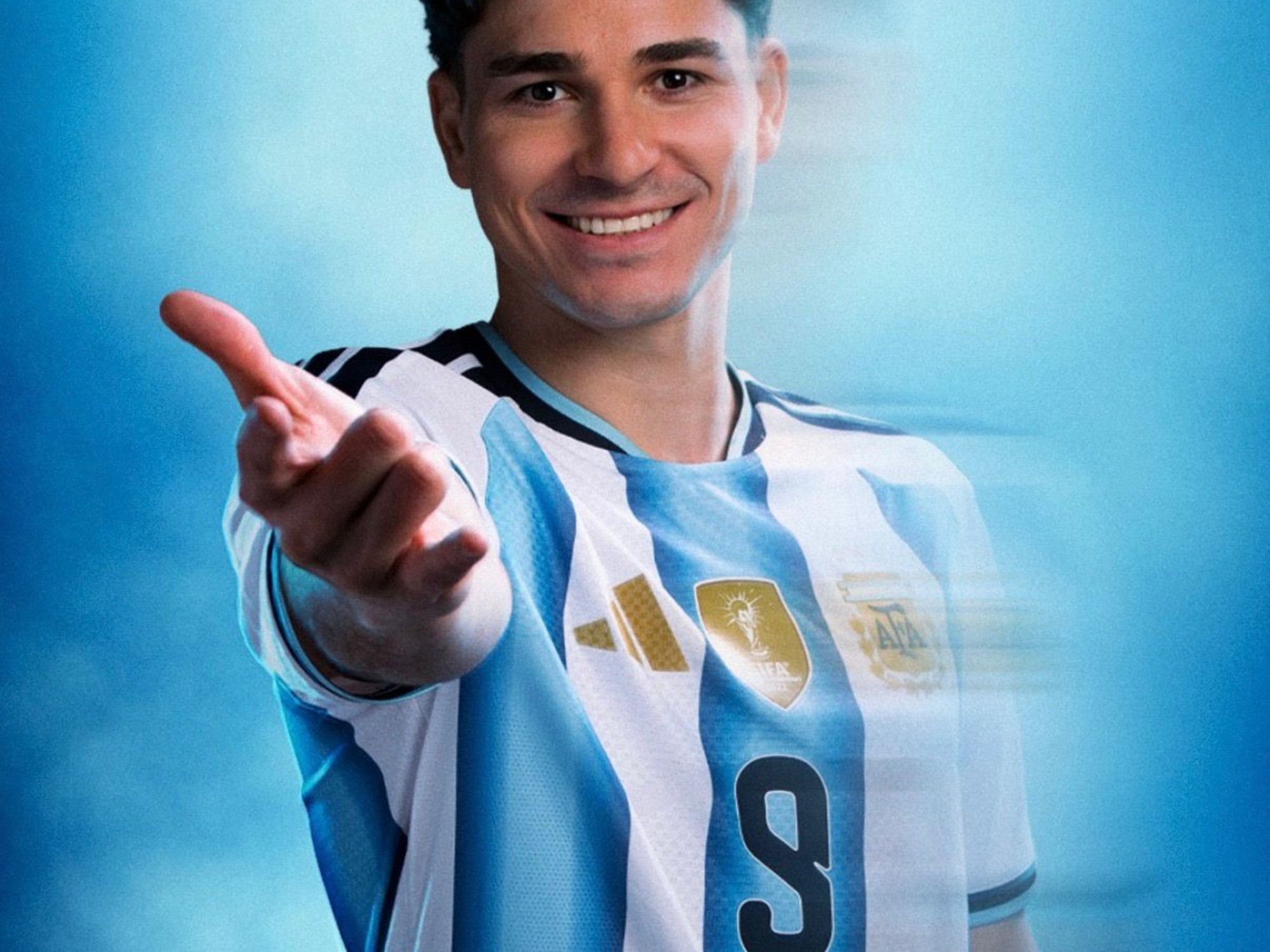 Julián Álvarez in an Argentina national team kit, smiling and looking determined.