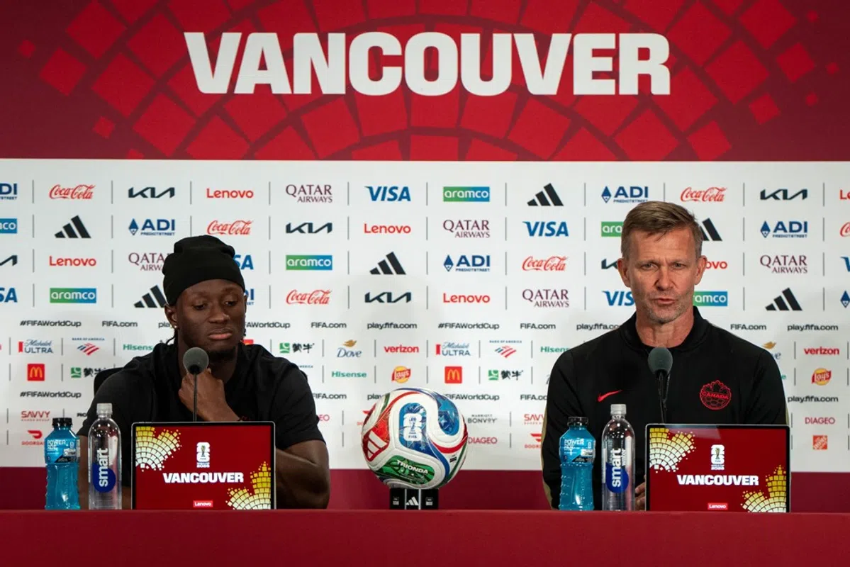 Ismaël Koné of Canada receiving medical attention on the field after an injury.