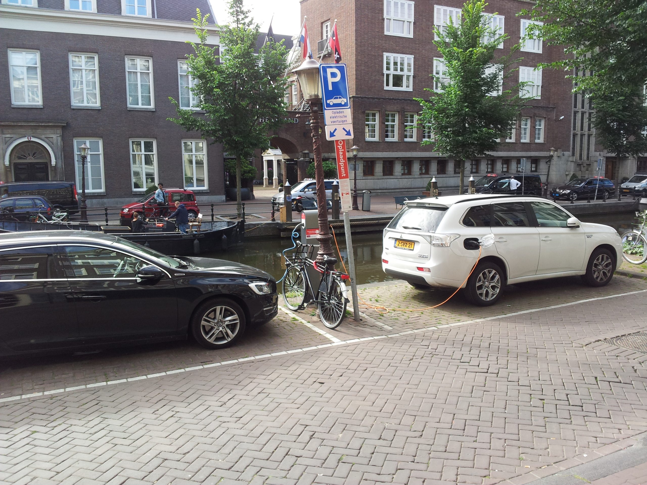 A plug-in hybrid car is plugged into a charging station.
