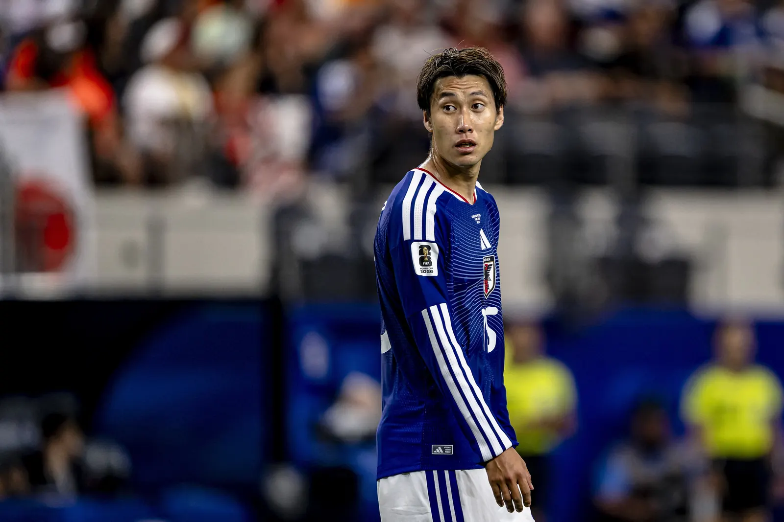Daichi Kamada celebrating with his Japanese teammates after scoring or making a key play during a FIFA World Cup match.