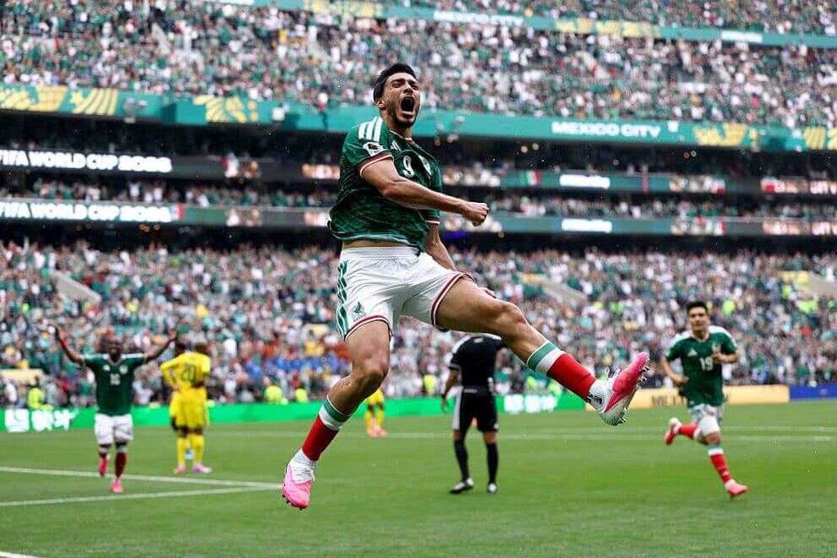 Enthusiastic Mexico national team fans cheer wildly inside the Azteca Stadium during a World Cup game.