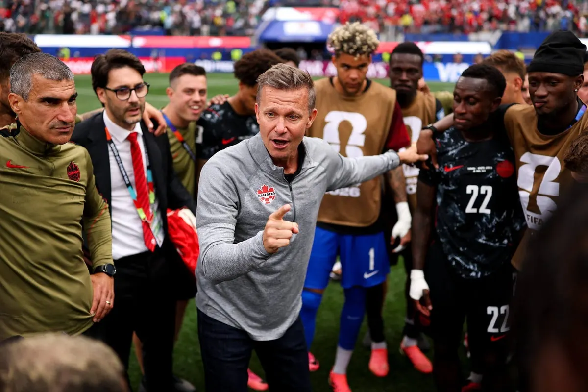 Canada head coach Jesse Marsch addresses his players on the field after a FIFA World Cup match.
