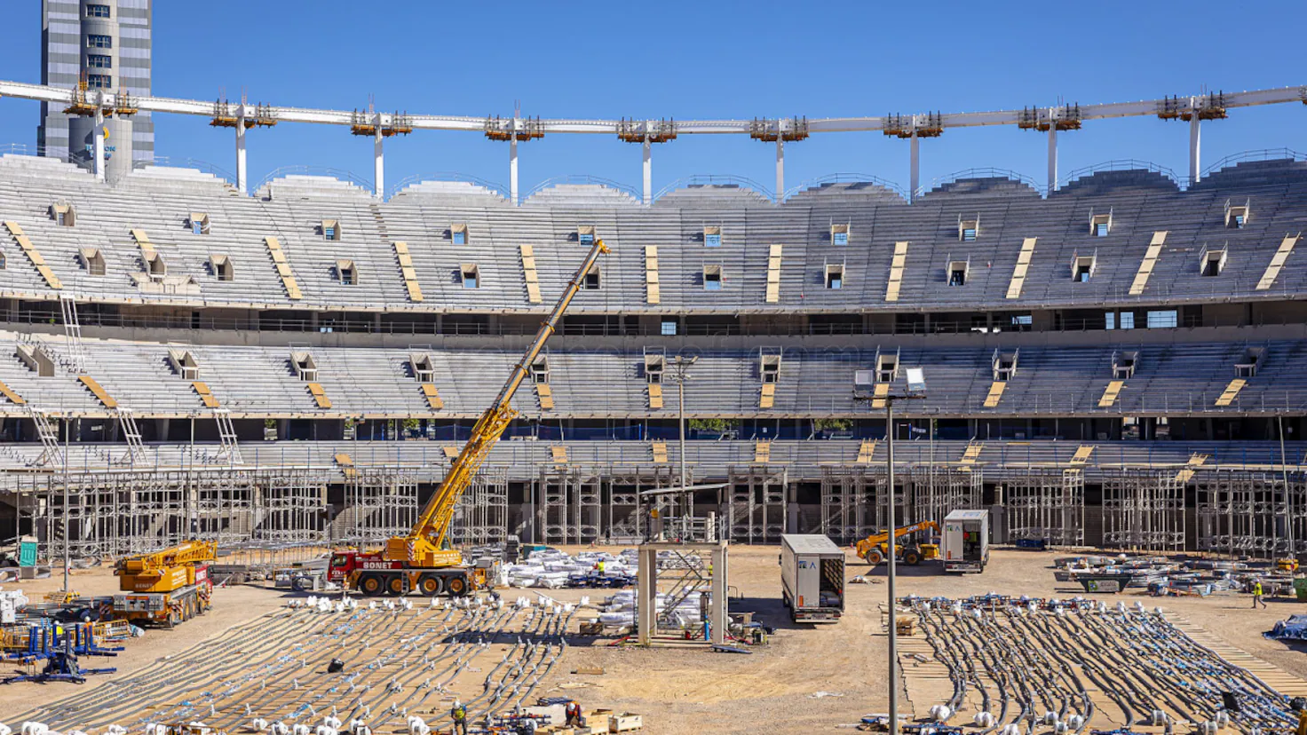 Construction workers and heavy machinery at the Nou Mestalla stadium site as pillars are installed.