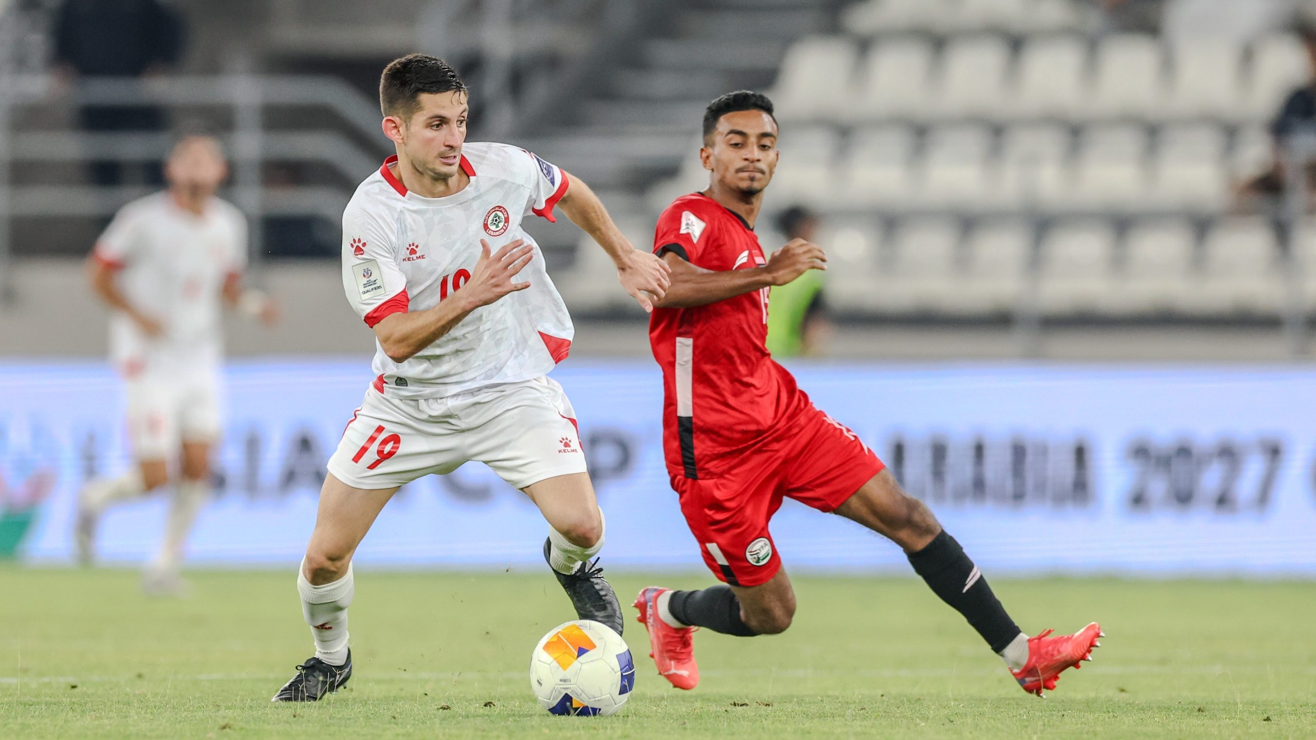 Football players from Lebanon and Yemen in action during an AFC Asian Cup qualifier match.
