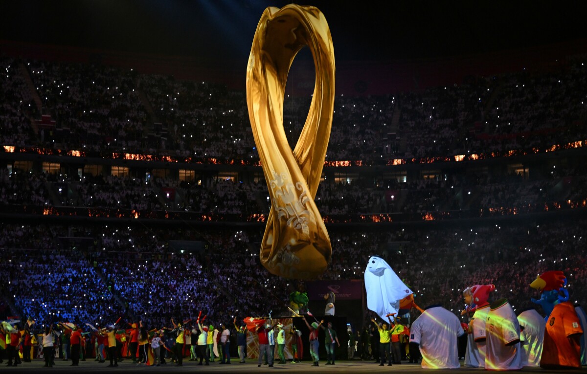 The FIFA World Cup Qatar 2022 trophy held aloft.