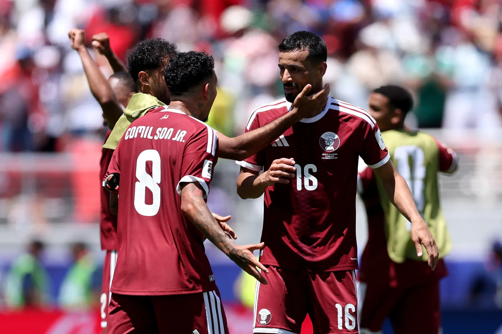 Qatar national football team players celebrating a goal during a FIFA World Cup match.