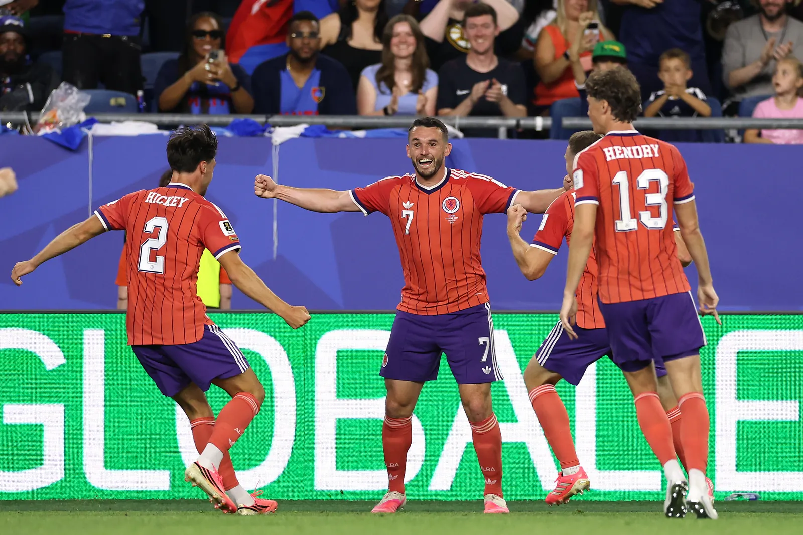 Scottish football players celebrating a goal during a match