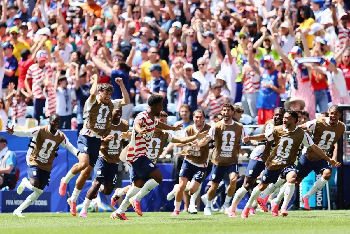 U.S. Men's National Team players celebrating a goal on the field.