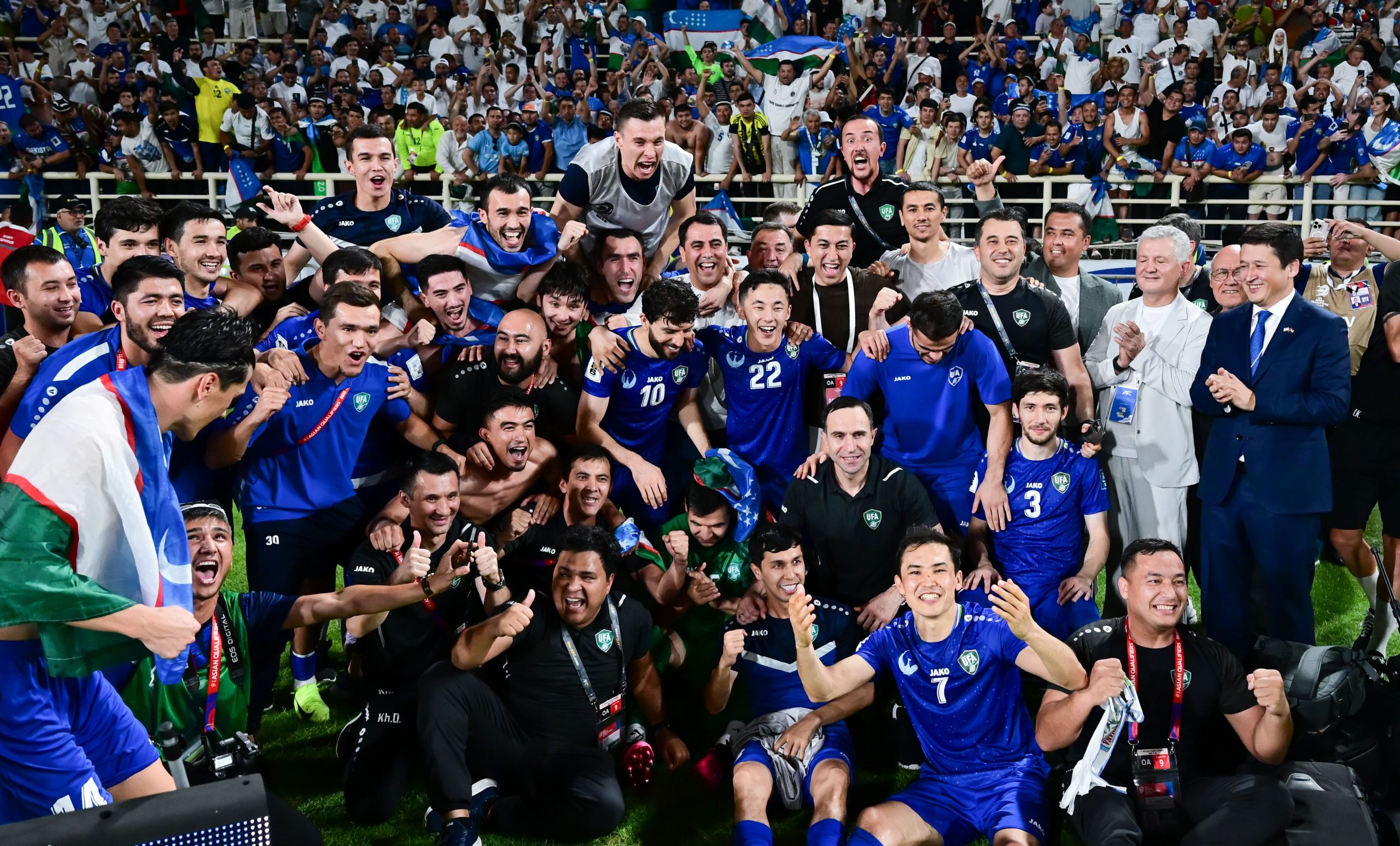Uzbekistan national football team players celebrating a goal.