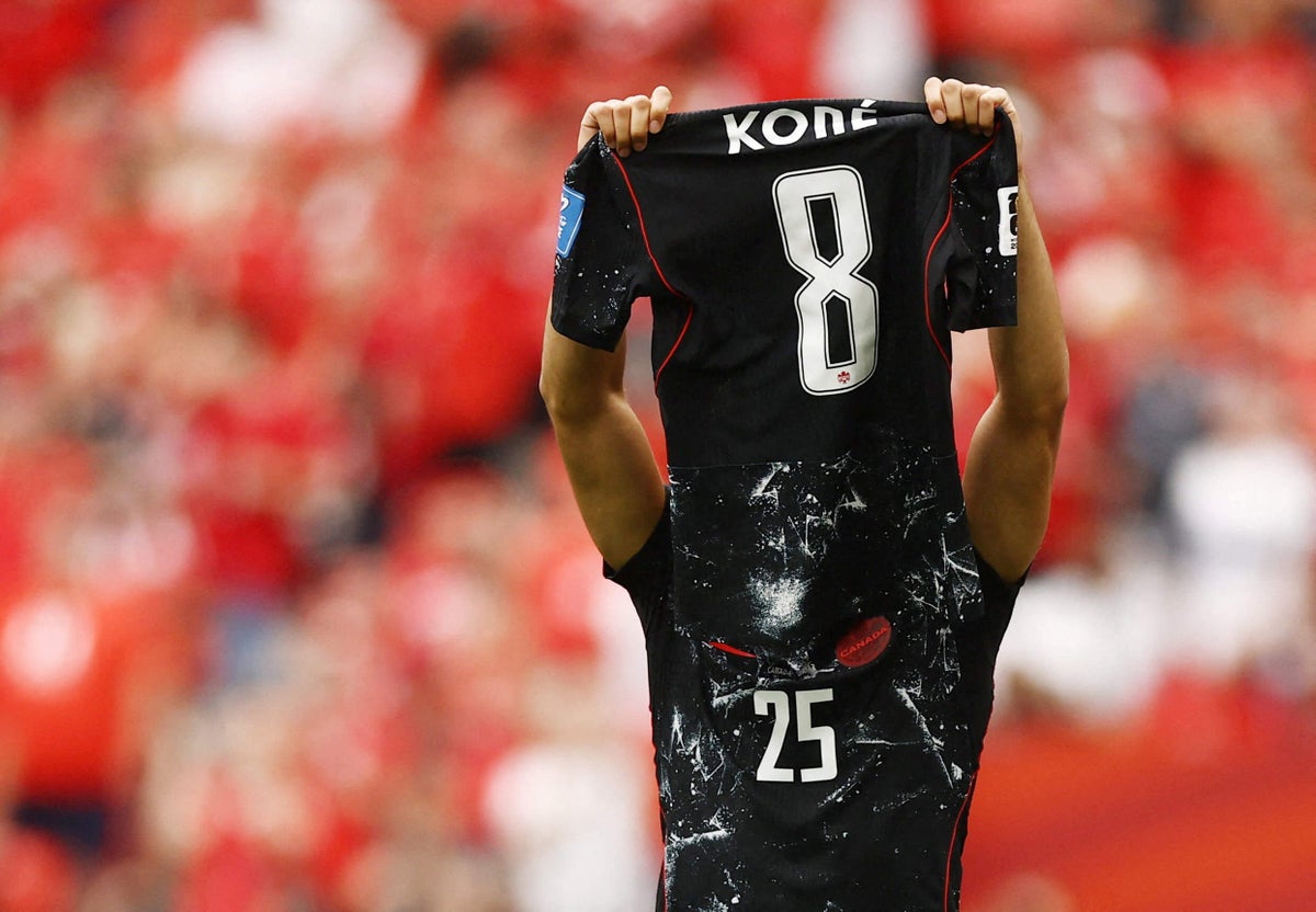 Ismaël Koné being attended to by medical staff on a stretcher after suffering a left leg injury during a FIFA World Cup match between Canada and Qatar.