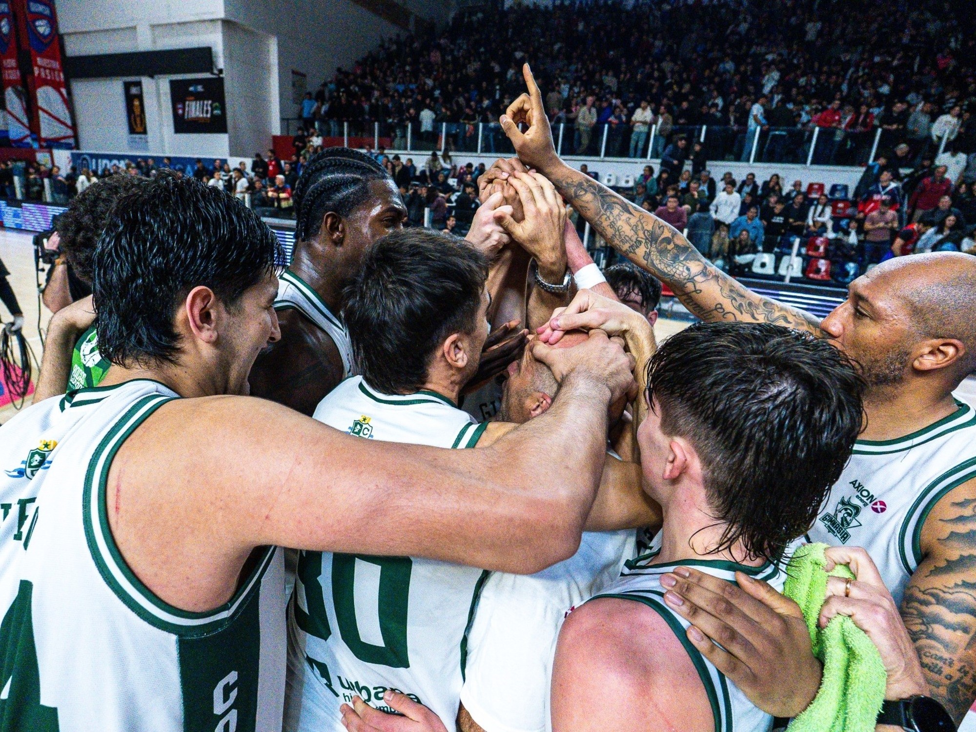 Gimnasia basketball players celebrating a successful play during a game.