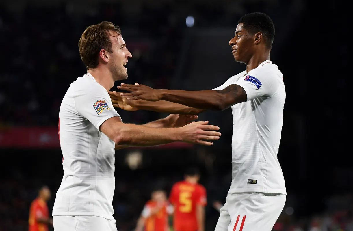 England players celebrating a goal on the pitch.