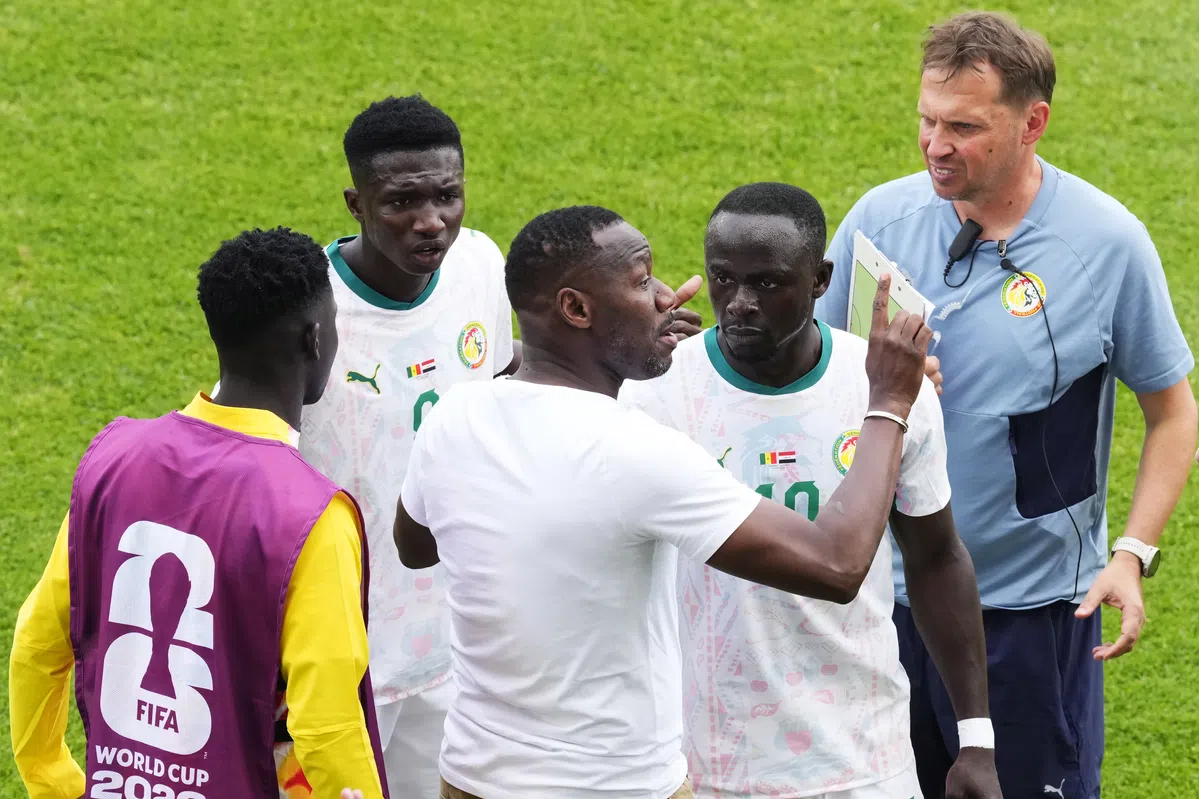 A football player from Senegal looking dejected on the field during a World Cup match.