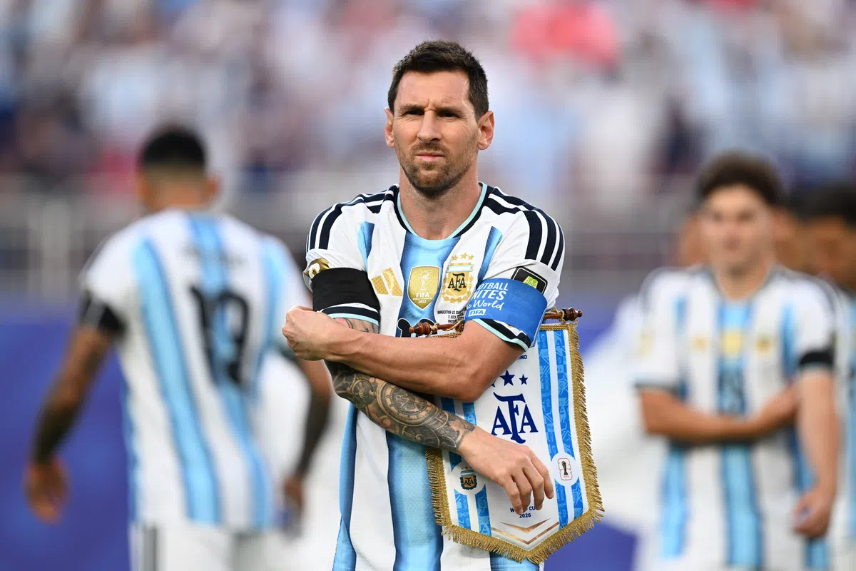 England players in action during a World Cup match, with Lionel Messi visible in the background.