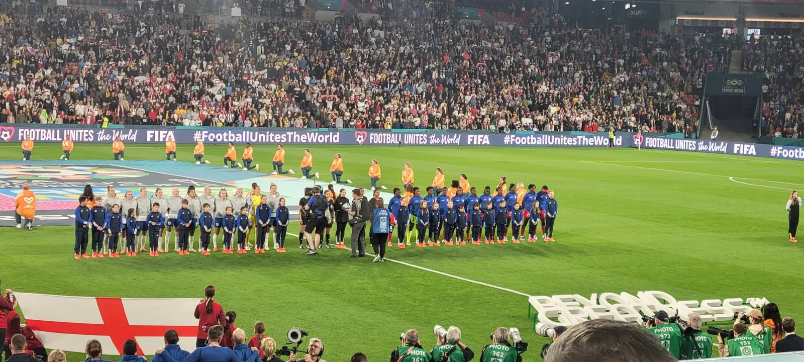 Donald Trump gestures while speaking, contrasted with an image of England players on the pitch during a World Cup game.