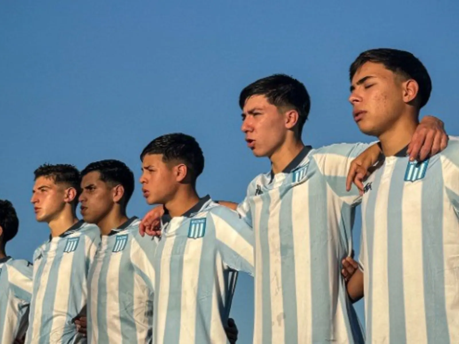 A youth football team in training attire on a pitch.