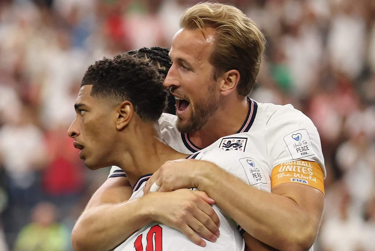 Jude Bellingham and Harry Kane celebrating a goal together for the England national football team on the pitch.