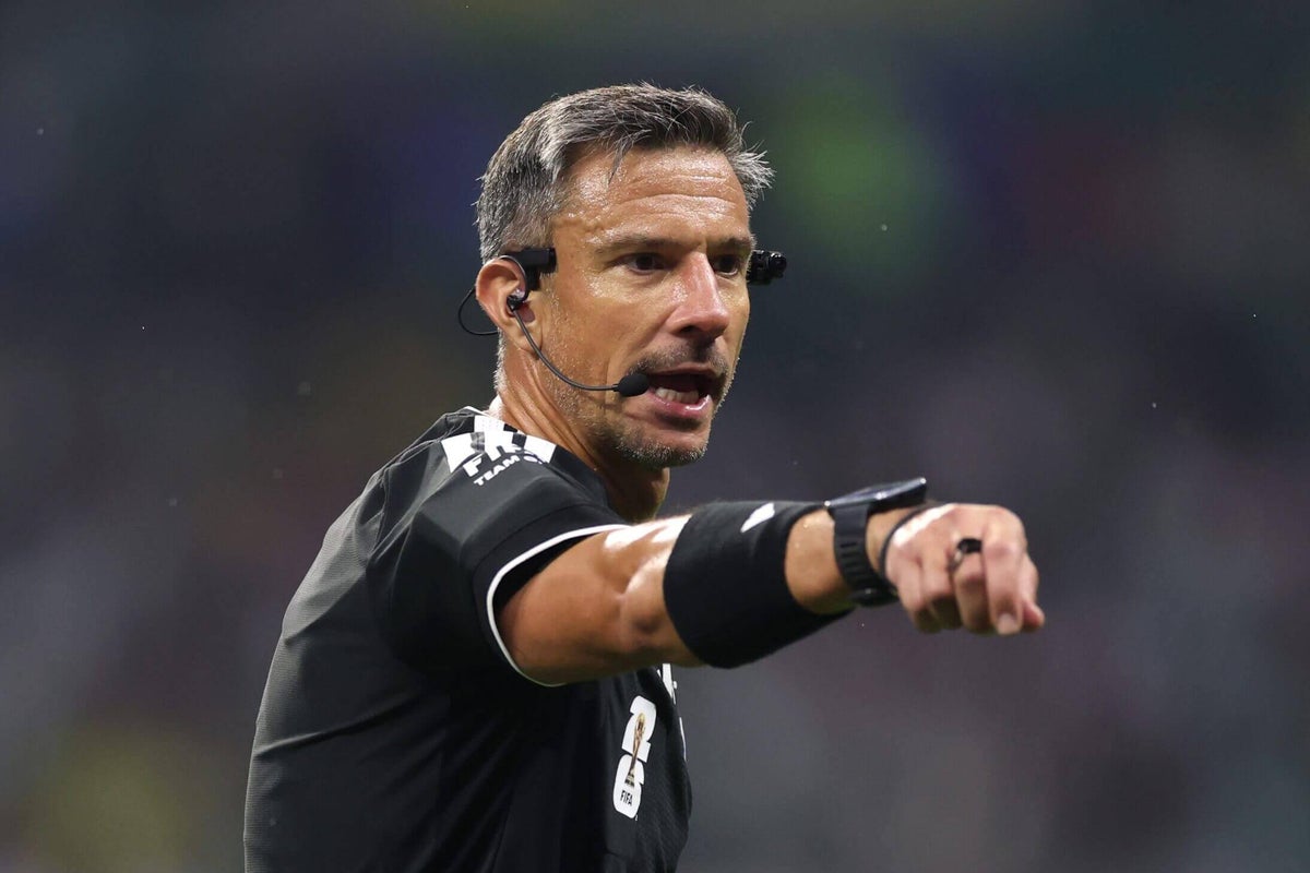 Referee Slavko Vincic on the pitch during a football match.