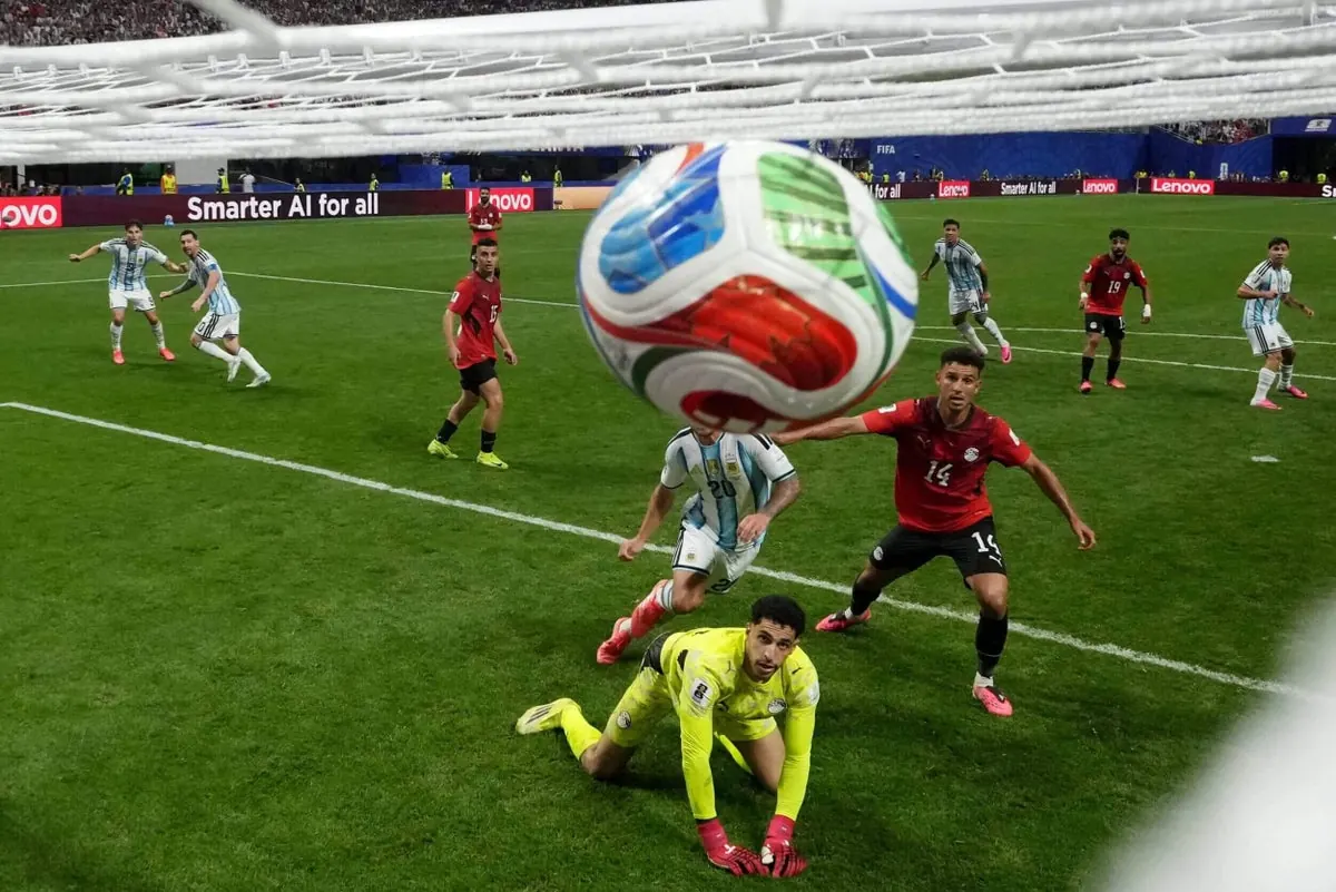 A football player shooting towards a goalkeeper during a World Cup match.