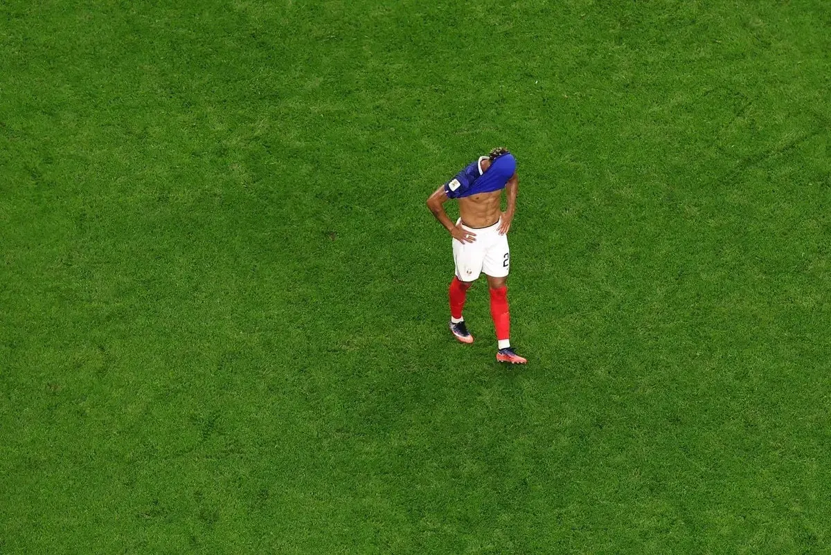 A dejected Kylian Mbappe of France stands on the pitch after their World Cup semi-final loss to Spain.