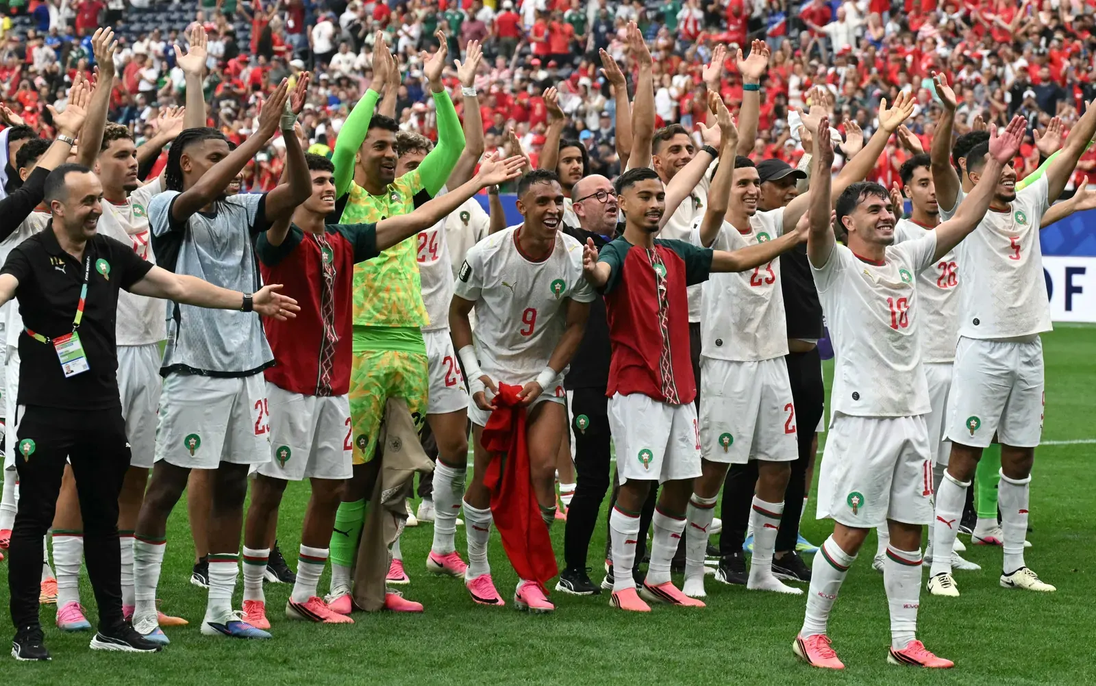 Morocco national football team players celebrating a goal on the pitch.
