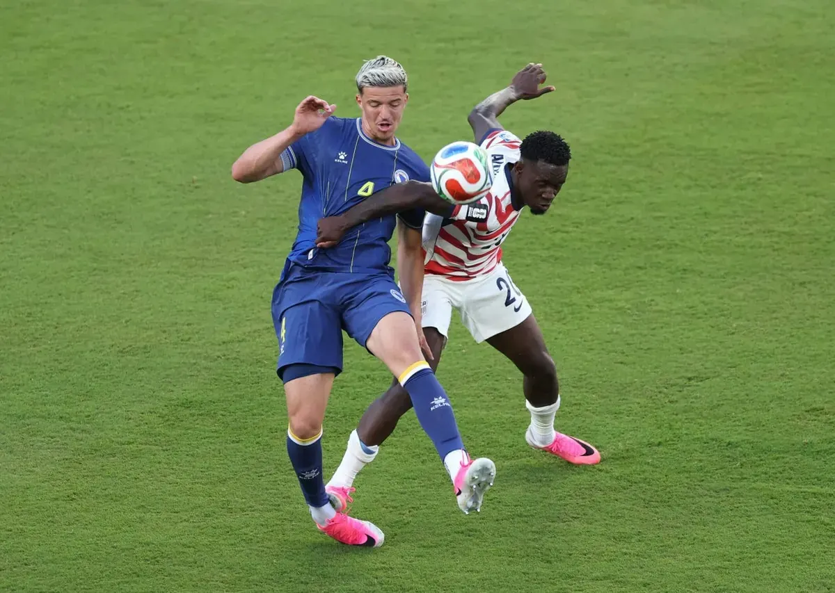 Folarin Balogun looks on as a referee shows him a red card during a World Cup match.