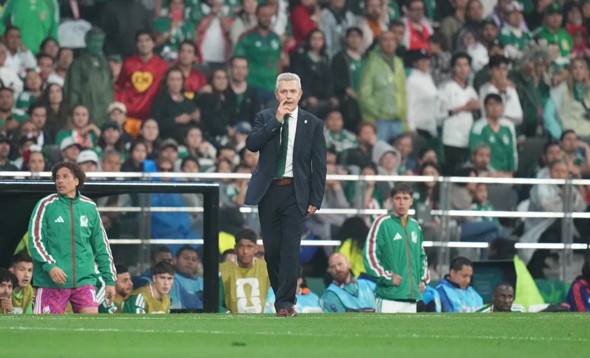 Mexico national football team players in training gear on a pitch.