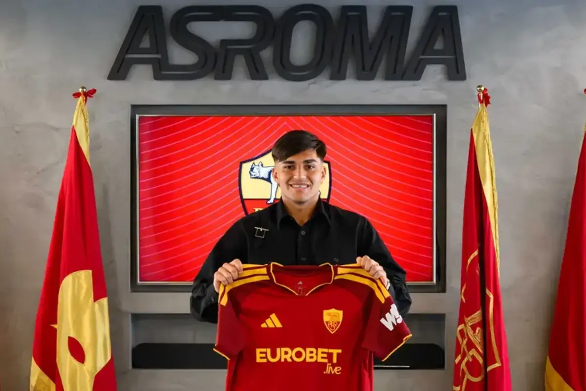 Santiago Castro smiling while holding Roma shirt during official unveiling at the Stadio Olimpico
