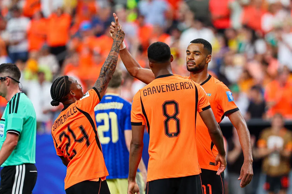 Football players celebrating a goal in a packed stadium during the 2026 FIFA World Cup